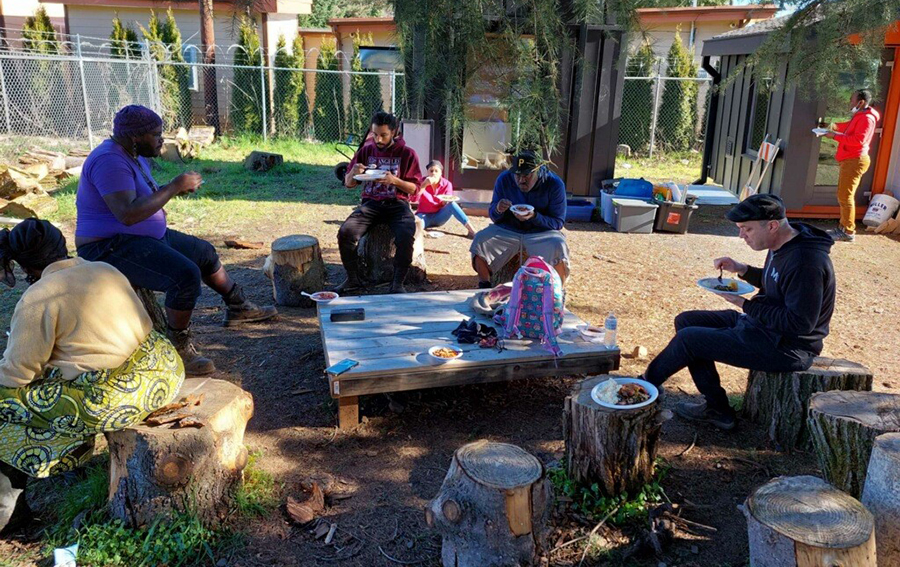 Bear enjoying a meal with others after a day of work at a community farm.