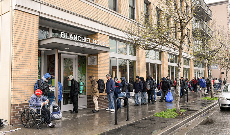 Guests in line for free food and meal services at Blanchet House. credit Justin Katigbak.
