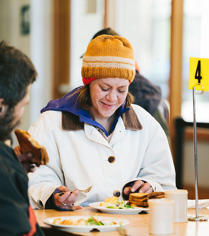 Woman eating at a table in Blanchet House. Blanchet House founders cafe free food meal services Christine Dong