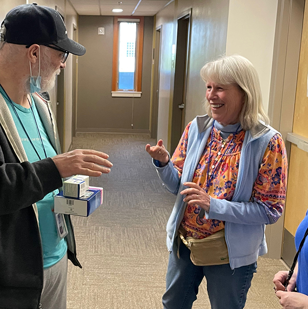 Volunteer Katie Hennessey talks with a resident at Blanchet House.